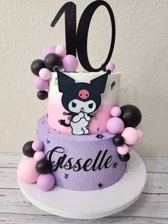 a cake decorated with pink, black and white balloons