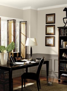 a home office with purple walls and wooden floors, along with a bookcase full of books