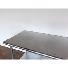 a metal table sitting in front of a white wall