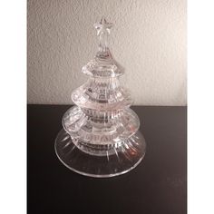 a clear glass christmas tree sitting on top of a table