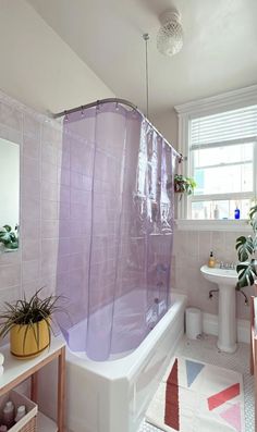 a bathroom with a purple shower curtain next to a sink