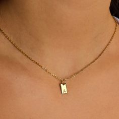 Double the charm and twice as personal, the Two Tiny Tag Initial Necklace is an exquisite celebration of identity and connection. Crafted in radiant gold, this necklace showcases two sleek rectangular pendants, each delicately engraved with a distinct initial. Add more initials that have meaning for you from our charm collection. However you customize the necklace, it will quickly become a favorite in your collection. Tag size: 10 mm x 5 mm Made of 14K gold-filled 18'' cable chain Hypoallergenic Initial Tag Necklace, Tiny Tags, Charm Collection, Gold Gifts, Charm Rings, Birthstone Necklace, Personalized Necklace, Bracelet Stack, Huggies Earrings