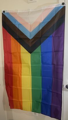 a rainbow colored flag hanging on the wall