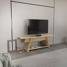 a flat screen tv sitting on top of a wooden stand in a living room next to a couch