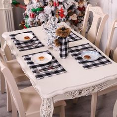 the table is set with black and white checkered placemats, silverware, and a teddy bear