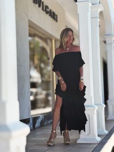 Indulge in the chic style of the Lucy Dress, featuring an off-the-shoulder design, delicate ruffled sleeves, and side seams with romantic ruffles. Modern side openings and a flowing maxi length complete the look. The double-layered body and single layered sleeves create a tantalizing contrast. Elevate your ensemble by pairing it with our Signature belts Elastic on Sleeve 100% Chiffon Lining 100% Chiffon Dry clean or Hand Wash or Delicate Cycle Wash and Hang Dry Designed with love in Miami, FL US Flowy Black Chiffon Dress With Ruffles, Black Asymmetrical Chiffon Dress, Black Asymmetrical Maxi Dress With Ruched Detail, Black V-neck Ruffled Maxi Dress, Multicolor V-neck Maxi Dress With Ruffle Hem, Black And White Flowers, Ruffled Sleeves, Mini Dress Casual, Kaftan Dress