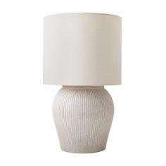 a white table lamp with a beige shade on it's base and a light bulb in the middle