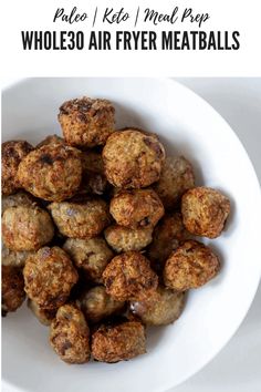 a white bowl filled with meatballs on top of a table