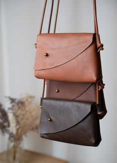 The Mini Asymmetrical Leather Bag - is handcrafted from soft, vegetable-tanned leather. Designed with a touch of simple elegance in mind, this compact wonder is your perfect partner for keeping your essentials right by your side. Whether it's your phone, keys, or small treasures, the gentle nature of the design ensures simplicity and comfort. Available in three hues - Tan, Brandy, and Chocolate Brown - it comes with a minimalist-style leather strap that can be customized to your preferred length Simple Leather Bag, Leather Bag Handmade, Handmade Leather Purse, Crossbody Leather Bag, Small Leather Purse, Small Leather Bag, Leather Sling Bag, Mini Tote Bag, Phone Pouch