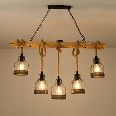 five lights hanging from a wooden beam with rope