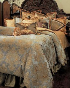 a bed with many pillows on it and a chandelier