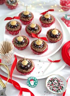 some cupcakes are sitting on a plate with red and white ribbons around them