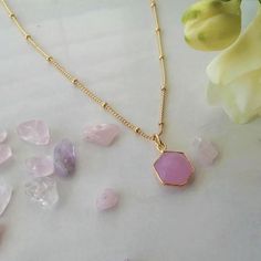 A beautiful and unique 'Harmony & Balance' Hexagon pendant necklace, carved from the semi precious Pink Chalcedony stone. Pink Chalcedony is associated with the heart chakra and is thought to bring the mind, body, emotions and spirit into harmony. In times of major change or upheaval, pink chalcedony has your back. The natural stone has been carved form a small hexagon shape. Because of its interlocking triangles, the hexagon is a symbol of harmony and balance. It is approximately 10mm diameter. It comes on an 18inch, 18ct gold plated satellite chain. Packaging Each necklace comes in a branded cotton pouch with a meaning card, packaged in a Lark & Stone branded gift box tied with ribbon. We can also add a gift message so this can be sent straight to the recipient. Additional Information Ea Gemstone Pendant Charm Necklace For Meditation, Gemstone Pendant Necklace For Her, Spiritual Crystal Necklaces With Gemstone For Her, Spiritual Gemstone Crystal Necklace For Her, Spiritual Crystal Necklace With Gemstone For Her, Rose Quartz Necklace With Natural Stones As A Gift, Spiritual Crystal Gemstone Necklaces As Gift For Her, Spiritual Adjustable Faceted Necklace, Amulet Style Agate Necklace For Gift