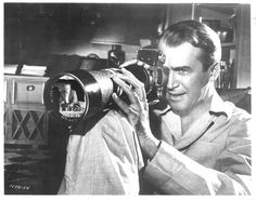 a black and white photo of a man holding a camera