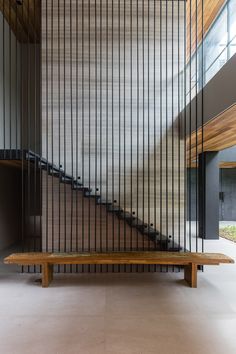 a wooden bench sitting in front of a stair case with metal bars on the wall