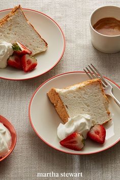 two plates with slices of cake and strawberries on them