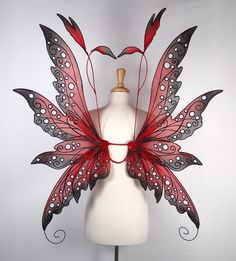 a white mannequin with red and black butterfly wings