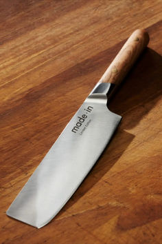 a kitchen knife sitting on top of a wooden table