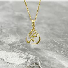 Crafted with precision and elegance, the Muhammad Necklace is a breathtaking piece of Islamic jewelry. Made from 925 sterling silver and expertly plated with 18K gold, this pendant exudes sophistication and beauty. The delicate Arabic calligraphy adds a touch of grace and culture to this exquisite necklace, making it a meaningful accessory for any occasion. Perfect for women who appreciate unique and meaningful gifts, this necklace is a stunning representation of faith and style. Embrace the essence of Islamic artistry with this captivating Muhammad Necklace, a timeless treasure to cherish and adorn. Ideal for those seeking a blend of spiritual significance and fashionable flair, it serves as a thoughtful and elegant addition to any jewelry collection. Size of Pendant: 0.67x1" | 1.7x2.6 cm Islamic Necklace, Arabic Necklace, Arabic Script, Arabic Jewelry, Islamic Jewelry, Wedding Map, Ramadan Gifts, Islamic Wall Art, Islamic Gifts