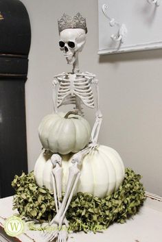 a skeleton sitting on top of some pumpkins