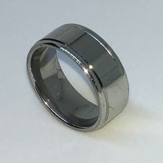 a silver ring with a thin edge on a white surface