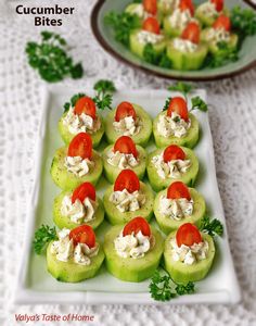 there are cucumber bites with tomatoes and cream cheese on the top, along with other appetizers