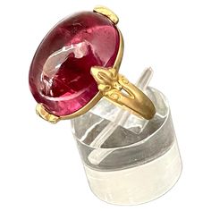 A clear 13 x 18 mm cabochon cut salmon pink tourmaline is held in 4 carved prongs in this Steven Battelle designed 18K gold setting. This allows for lots of light interplay and a lively stone. A tapered matte finish shank currently sized 7 completes. This ring is resizable. exquisite... Oval Tourmaline Jewelry For Formal Occasions, Formal Oval Tourmaline Jewelry, Luxury Tourmaline Jewelry In Oval Cabochon Shape, Luxury Tourmaline Oval Cabochon Jewelry, Luxury Tourmaline Jewelry With Oval Cabochon, Elegant Oval Ruby Ring With Intaglio, Elegant Round Ruby Intaglio Ring, Elegant Round Ruby Ring With Intaglio Detail, Pink Spinel