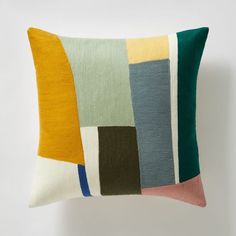 a multicolored pillow sitting on top of a white wall