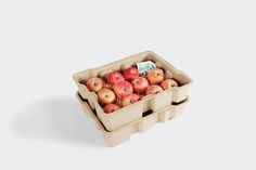 an open carton of apples on a white background