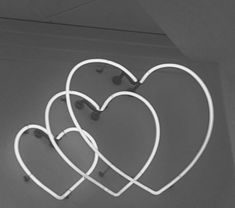 three heart shaped neon signs hanging from the ceiling