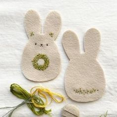 two bunny ears are sitting next to each other on a white towel with green string