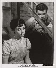 an old black and white photo of a woman sitting next to a man