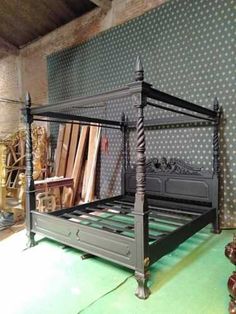 an antique bed frame in the middle of a room with polka dots on the walls