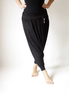 a woman in black pants is standing with her hands on her hips