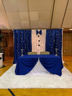 a blue and white stage set up for a wedding or event with lights on the ceiling