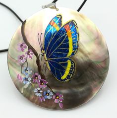 Mother of pearl pendant with 3D design Blue butterfly painted on gold leaf and mother of pearl 3D background Entirely hand painted and hand made, signed work Atlantic mother of pearl, thick shell Mother of pearl back D.6cm Jewellery cord full length approx 60cm, adjustable Lobster claw clasp Comes with an organza gift pouch Handmade Shell Pendant Necklace For Gift, Unique Mother Of Pearl Shell Necklace Gift, Handmade Blue Mother Of Pearl Jewelry, Elegant Blue Shell Necklace For Gift, Elegant Blue Shell Necklace As A Gift, Handmade Blue Shell-shaped Necklace, Handmade Butterfly Pendant Necklace, Hand Painted Blue Round Pendant Necklace, Blue Hand Painted Round Pendant Necklace