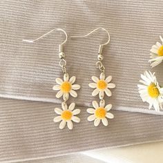 These adorable white daisy chain dangle earrings are the perfect unique summery accessory. The polymer clay they are made from is very lightweight and comfortable, and each pair is slightly different due to the nature of handmade products. White Dangle Flower Earrings For Spring, Minimalist White Jewelry For Spring, White Daisy-shaped Jewelry For Spring, Dainty White Earrings For Spring, White Daisy-shaped Spring Jewelry, White Flower Charm Earrings For Everyday, White Daisy Jewelry For Everyday, White Daisy-shaped Everyday Jewelry, Dainty White Dangle Flower Earrings