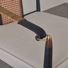 a close up of a chair with a metal handle on it's backrest