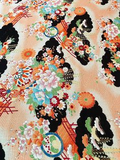 an orange, black and white floral print fabric with many flowers on the top of it