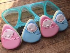 three decorated baby shoes sitting on top of a wooden floor next to a pair of glasses