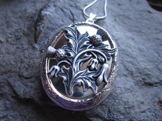 "Beautiful locket choose from silver plated or gold plated. Scotland's national emblem since the 1400's. The thistle has amazing details and is professionally plated and oxidized, to enhance the quality, and completely lead and nickel free. The locket is Victorian style with beautiful etching on both the front and back 2\" long, please see the photos for size. It can hold two photos, keepsakes, or even your daily medication or vitamins. Pass down from generation to generation. The chain is a mat Ornate Locket Brooches For Gifts, Traditional Wedding Jewelry With Engraving Option, Traditional Ceremonial Jewelry With Engraving Option, Heirloom Engraved Brooch For Wedding, Heirloom Engraved Brooches For Wedding, Antique Silver Jewelry With Engraving Option, Antique Silver Locket Necklace For Wedding, Victorian Round Pendant Jewelry For Commemoration, Medallion Brooch Jewelry For Wedding