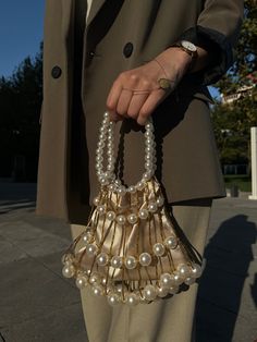 Elevate your style with our exquisite bridal clutch bag, crafted for both brides and guests attending special events. The luxurious mink color satin provides a sophisticated backdrop, complemented by large white pearls that encircle the bag, creating an opulent and timeless look. The handle, adorned with white pearls, adds a touch of glamour and refinement. Whether you're walking down the aisle or attending a special event, this clutch is designed to make a statement. The meticulous craftsmanship, coupled with the use of yellow threads, adds a subtle warmth, making it versatile for both daily and wedding occasions. Key Features: Luxurious mink color satin White pearl handle for a touch of elegance Large white pearls embellish the bag Versatile for daily and wedding events Meticulous crafts Pearl Clutch Bag, Bridal Clutch Bag, Pearl Clutch, Mink Colour, Wedding Handbag, Bridal Bag, Bridal Clutch, Pearl Wedding, White Pearl