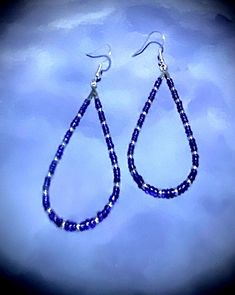 These beautiful 2 3/4" earrings are made with blue and purple and silver seed beads. These beads are a nice embellishment to the classic teardrop hoop earrings. These teardrop earrings are very comfortable because they are so lightweight.  Hoop earrings are classic, and these are teardrop hoops, with a pattern that makes a statement. You can't go wrong with these earrings! They are great all year round. These would be great on to wear on July fourth! They come in a box for easy gift giving too. They are a great birthday, Mother's Day, or Christmas gift! 1006 Dangle Teardrop Earrings With Tiny Beads As Gift, Blue Teardrop Hoop Earrings With Dangling Beads, Blue Teardrop Jewelry With Silver Beads, Gift Teardrop Dangle Earrings With Tiny Beads, Blue Hoop Earrings With Dangling Beads Gift, Blue Dangle Hoop Earrings With Tiny Beads, Blue Teardrop Earrings With Dangling Beads, Blue Beaded Teardrop Earrings For Gift, Handmade Blue Teardrop Hoop Earrings