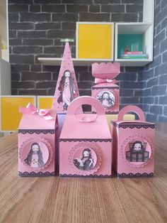 three pink boxes with pictures on them sitting on a table