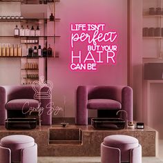 a pink room with two chairs and a stool in front of the wall that says, life isn't perfect but your hair can be