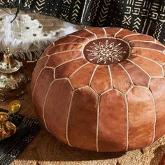 a large brown ottoman sitting on top of a rug next to other decorations and decor items