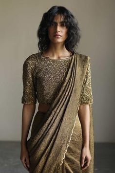 Gold sequin embroidered boat neck blouse.
Component: 1
Pattern: Woven, Embroidered
Type Of Work: Textured
Neckline: Boat neck
Sleeve Type: Elbow sleeves
Fabric: Chanderi silk
Color: Gold
Other Details: 
Piping detail
Note: Saree worn by the model is not for sale
Occasion: Wedding, Reception - Aza Fashions Saree With Boat Neck Blouse, Zero Neck Blouse Design, Jewelry For Boat Neck Blouse, Close Neck Blouse, Golden Blouse For Saree, Blouse With Piping Designs, Gold Color Blouse Designs, Silver Blouse Designs Boat Neck, Sequins Blouse Designs