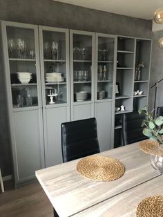 the dining room table is set with place mats and placemats, along with black leather chairs