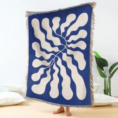 a woman standing in front of a blue and white blanket