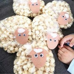 a child's hand is touching some popcorn in the shape of sheep